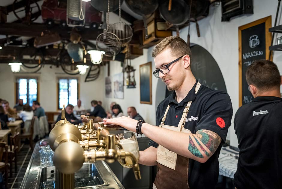 Tjener skænker en øl i Pilsner Urquells ølkælder i Prag i Tjekkiet.