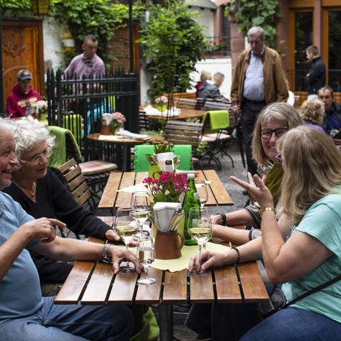 Frokost og et glas hvidvin i Drosselgasse i Rüdesheim i Tyskland.
