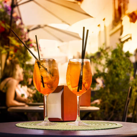 To glas med Aperol Spritz på et bord ved en fortovscafé i Italien.