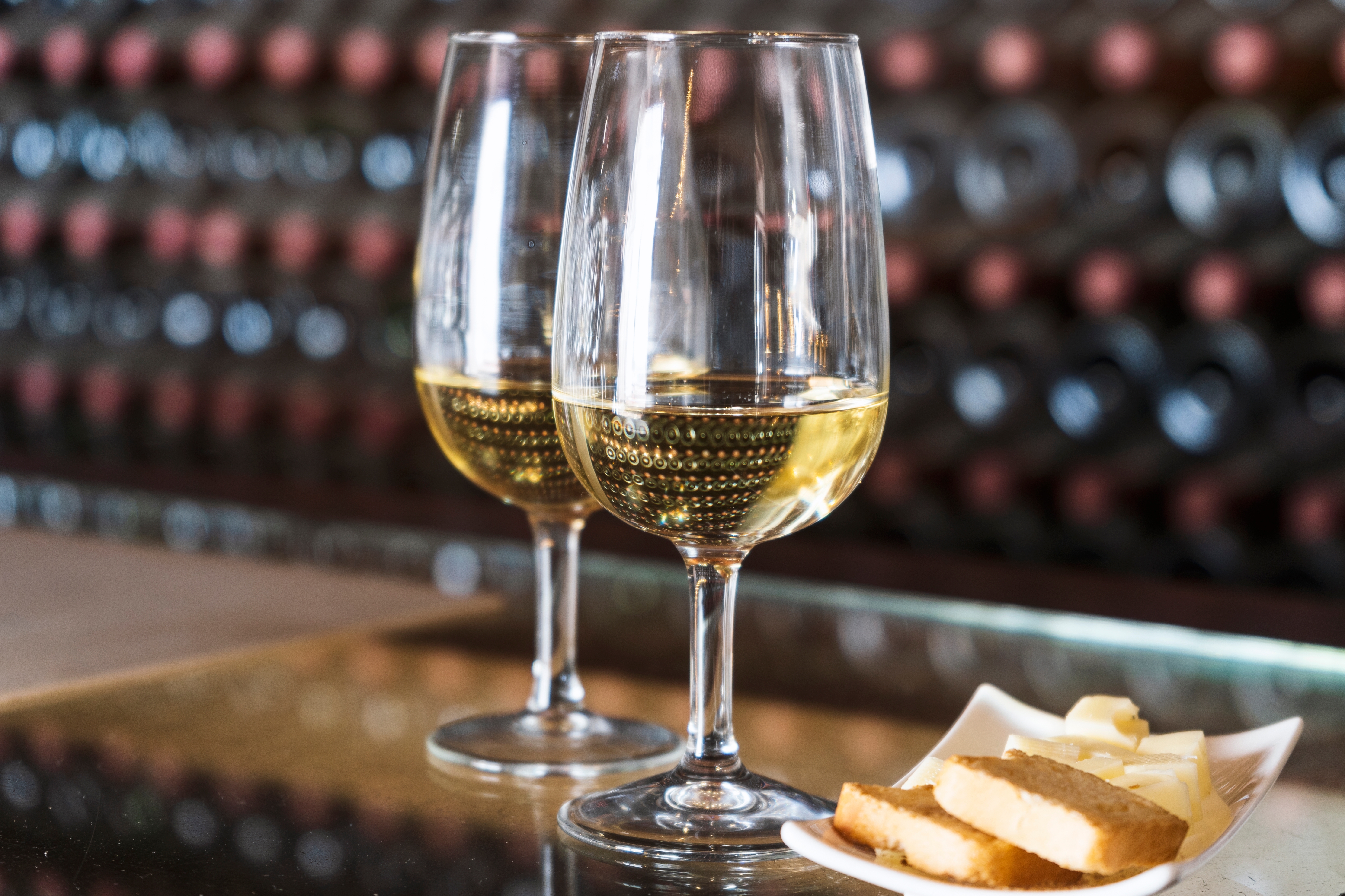 To glas med vin og en tallerken med brød ved en vinsmagning i Spanien.