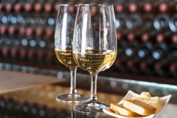 To glas med vin og en tallerken med brød ved en vinsmagning i Spanien.