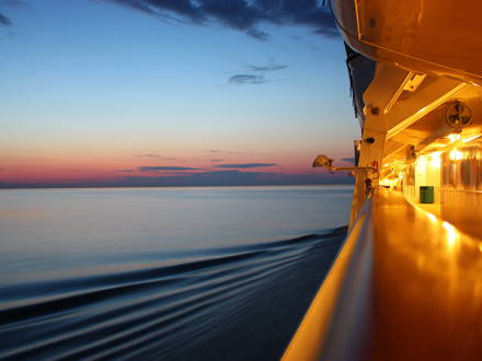 Udsigt over aftenhimlen fra rælingen på et krydstogtskib.