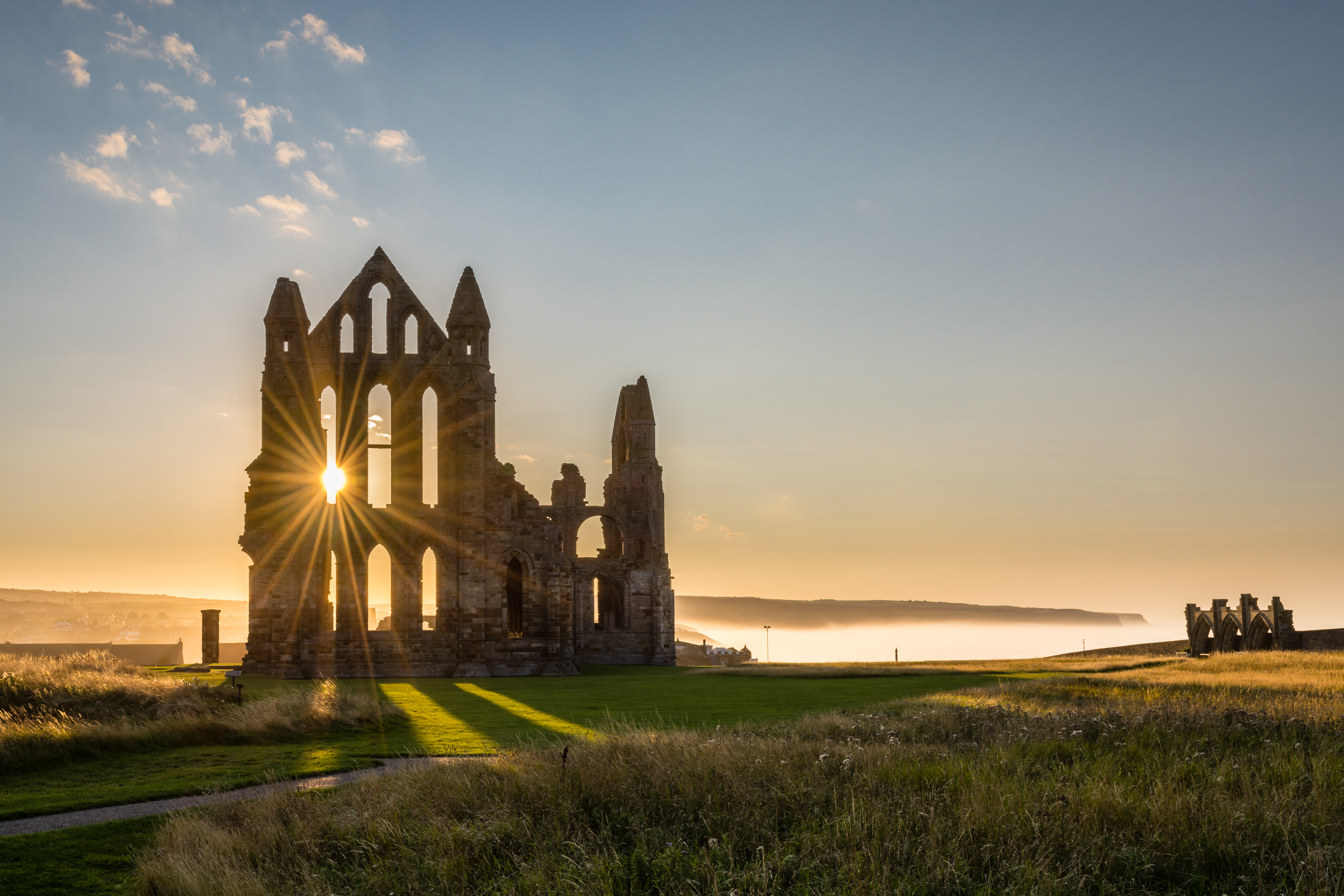Solopgang ved ruinerne af Whitby Abbey i England.