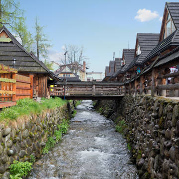 Vandløb, der løber mellem træhuse i Zakopane i Polen.