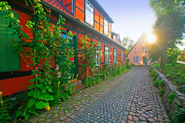 Brolagt gade og rødt bindingsværkshus i Stralsund i Tyskland.