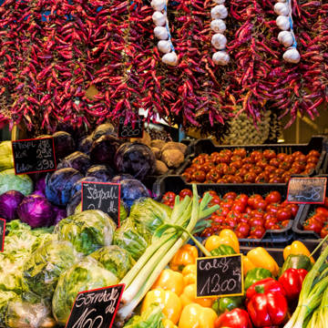 Salgsbod fyldt med frugt, grønt og tørrede chilier i en markedshal i Budapest i Ungarn.