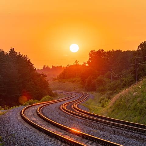 Jernbaneskinner i solnedgangen.