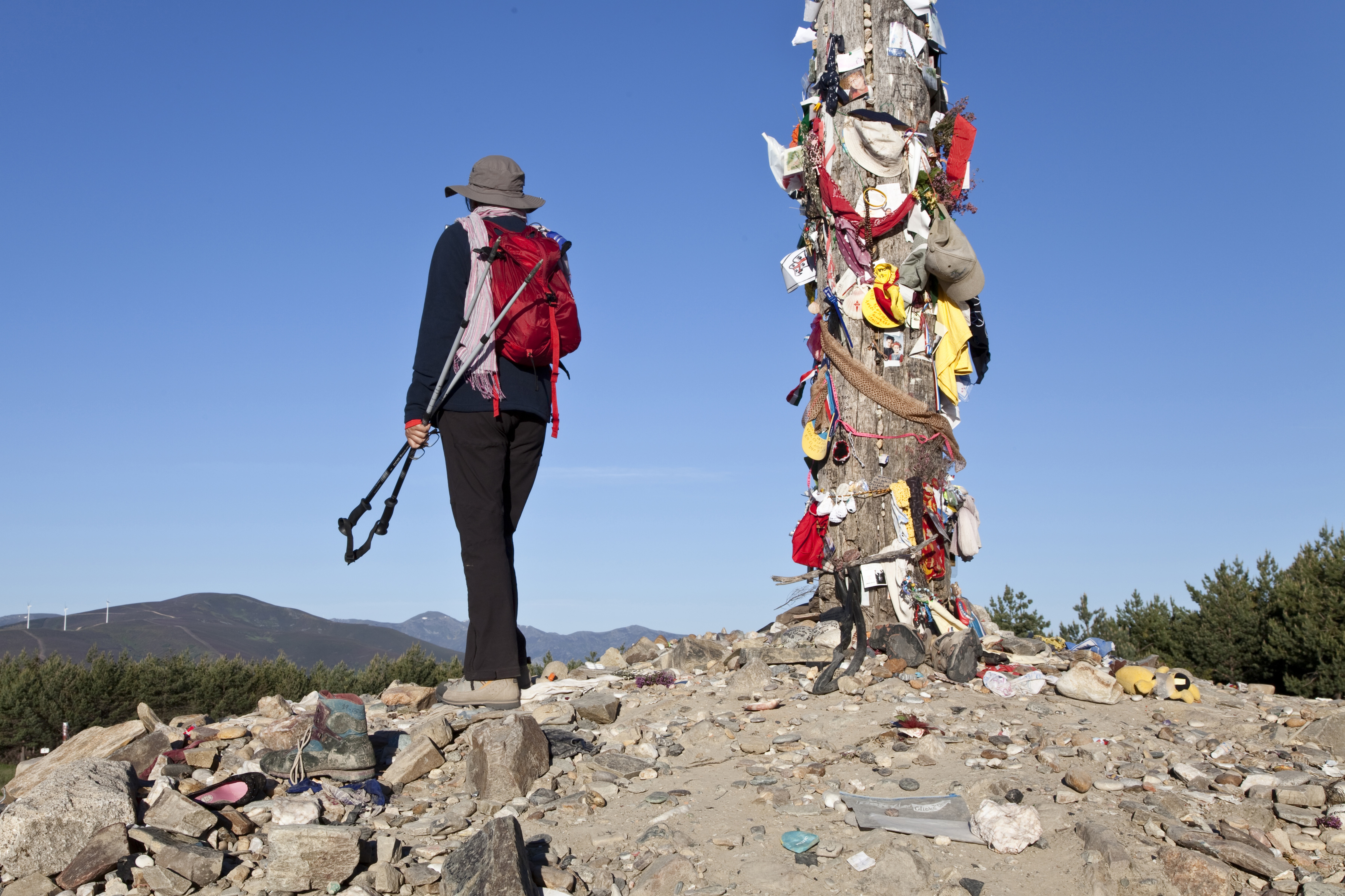 Vandrer stå ved Jernkorset på Caminoen i Spanien.