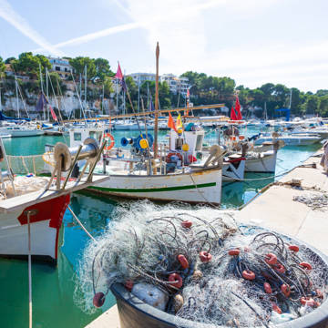 De charmerende fiskerbåde i marinaen i Porto Cristo på Mallorca i Spanien.