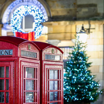 To klassiske røde telefonbokse med juletræ i baggrunden ved Covent Garden i London i Storbritannien.