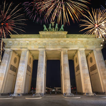 Brandenburger Tor i Berlin under en nytårshimmel oplyst af fyrværkeri.