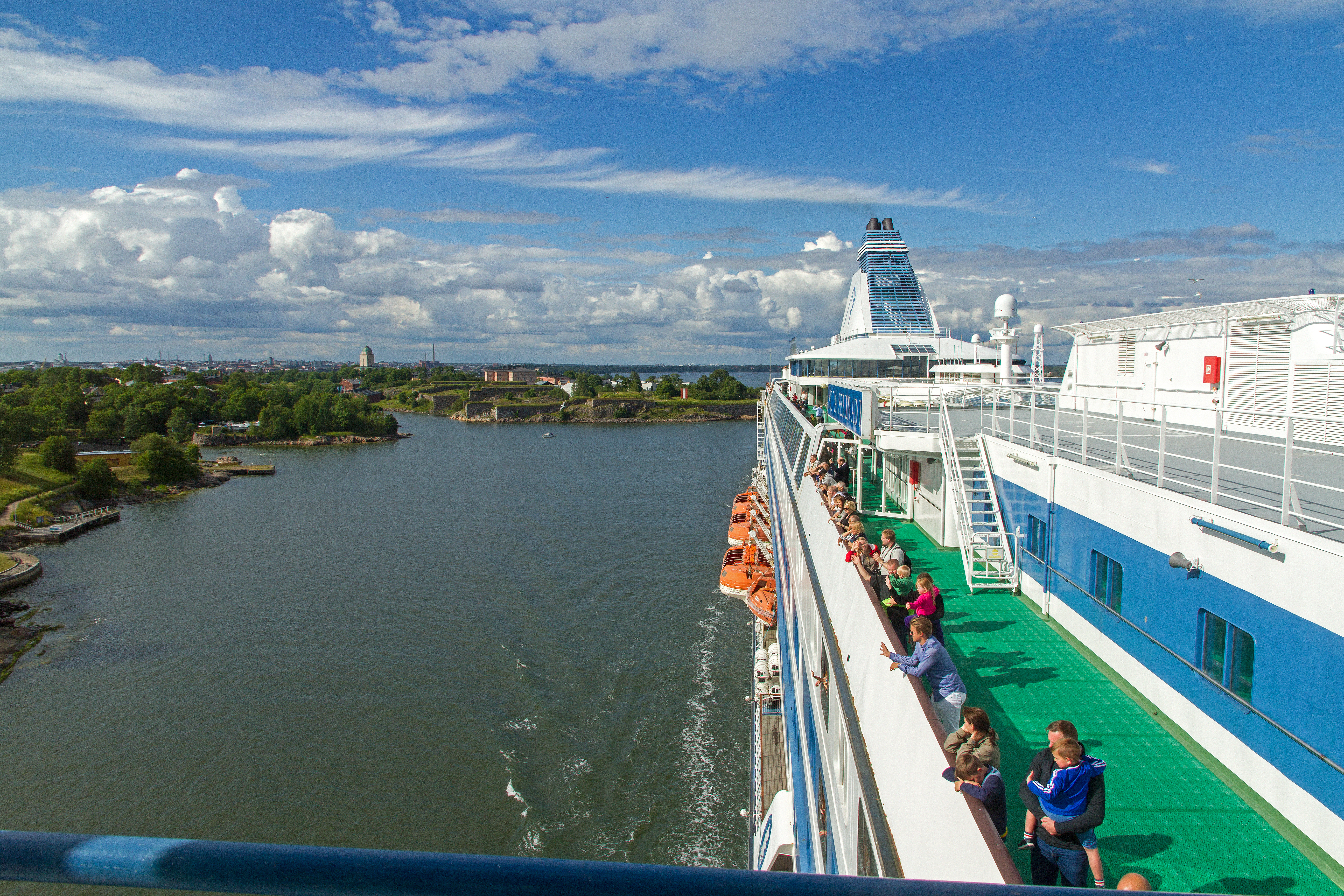 Passagerer nyder udsigten om sommeren fra rælingen ombord på Silja Symphony i den stockholmske skærgård.