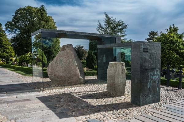 De to jellingesten i glasmontrer uden for kirken i Jelling i Danmark.