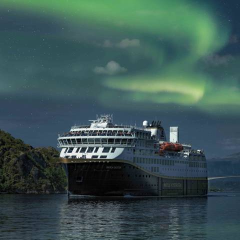 Krydstogtskib i nordlys i Nordnorge.