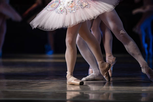 Balletdanseres ben på scenen.