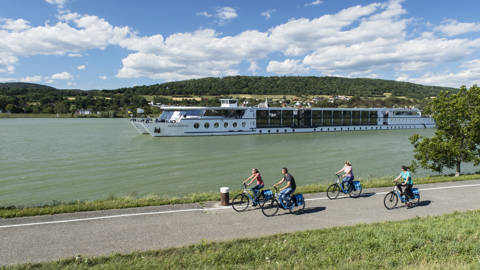 Cyklister kører på en cykelsti langs flodbredden på rejsen Cykelkrydstogt på Donau med MS Primadonna.