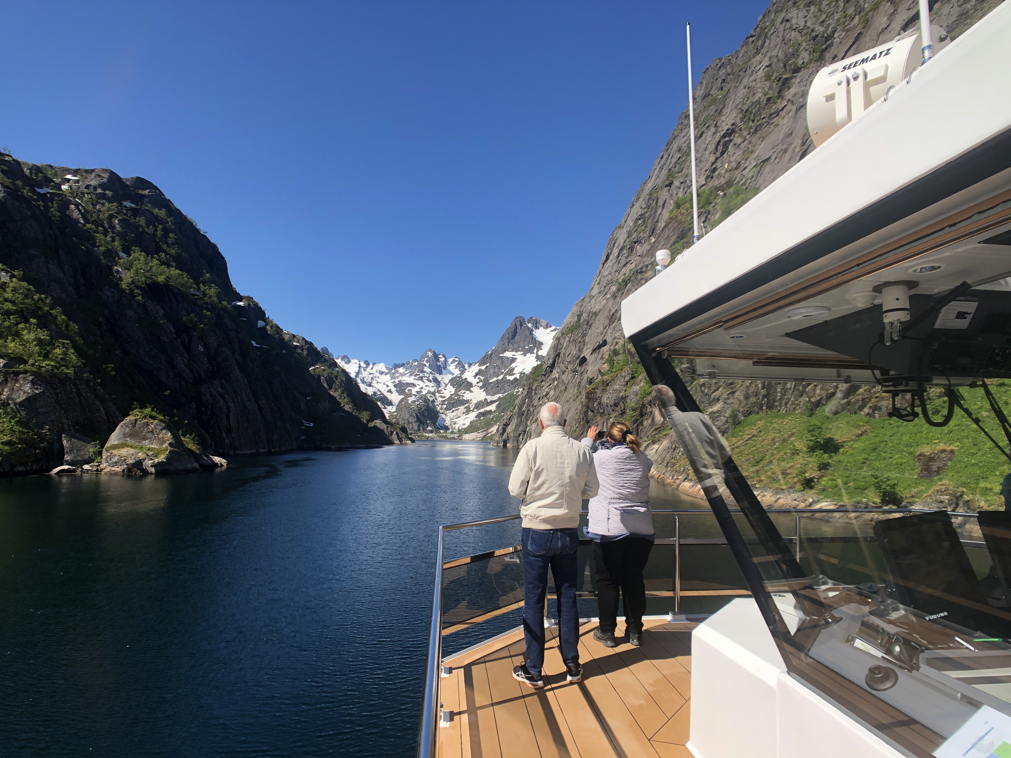 To mennesker i stævnen af et elektrisk drevet skib i Trollfjorden i Norge.