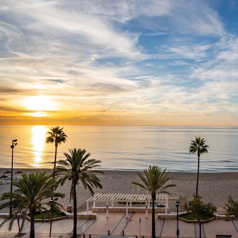 Solopgang ved stranden ved Fuengirola på Costa del Sol i Spanien.