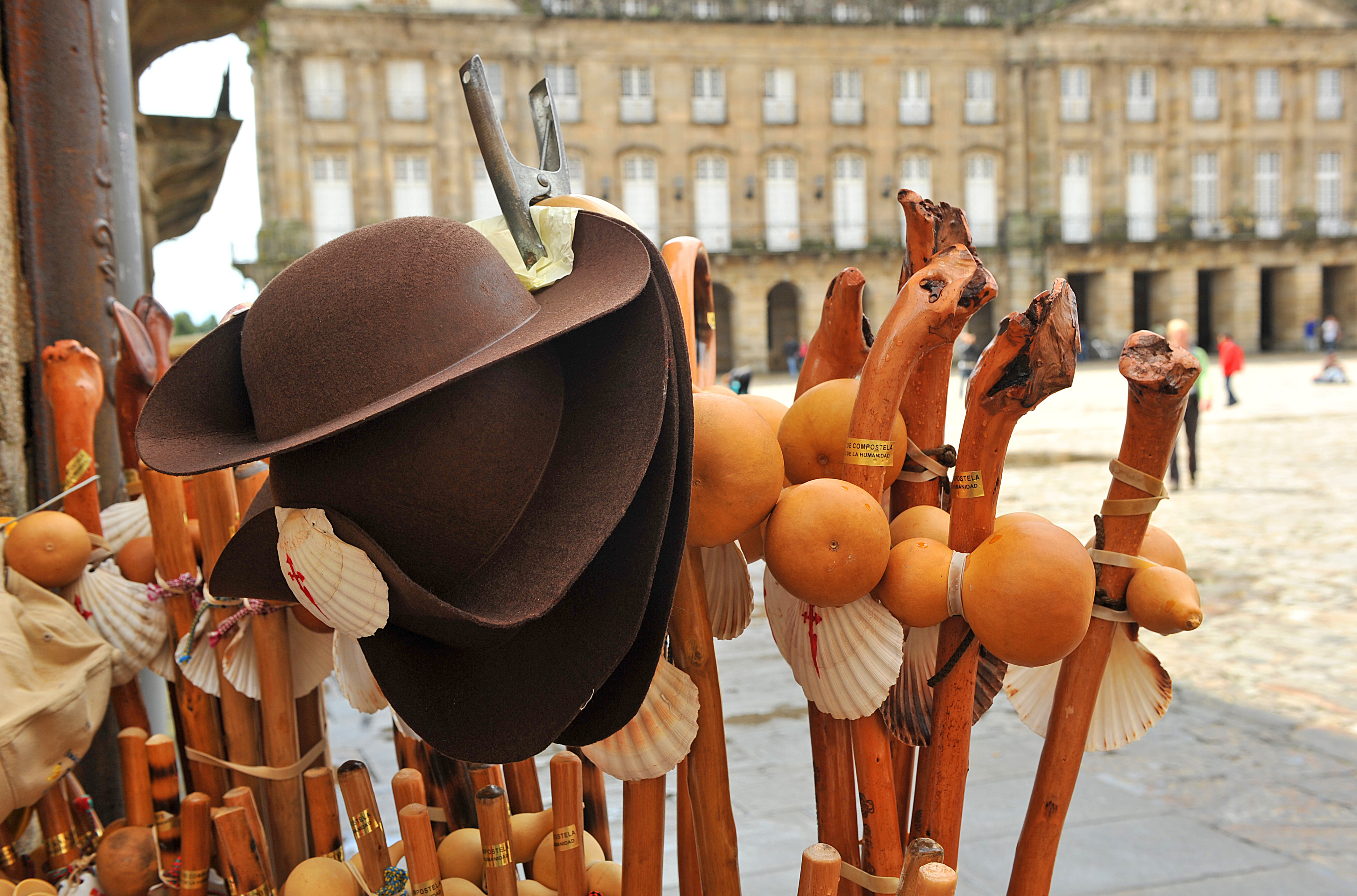 Bod med vandrestokke, muslingeskaller og hatte på den pladsen foran katedralen i Santiago de Compostela i Spanien.