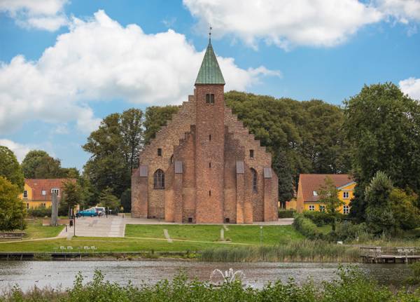 Maribo Domkirke set udefra med Søndersø i forgrunden.