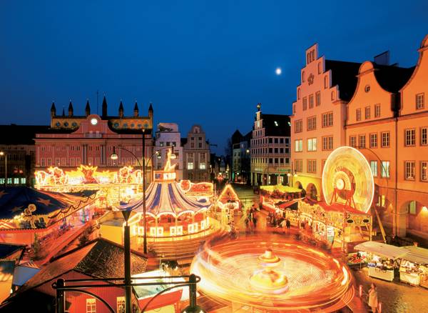 Julemarked og karusseller i smuk aftenbelysning i Rostock i Tyskland.