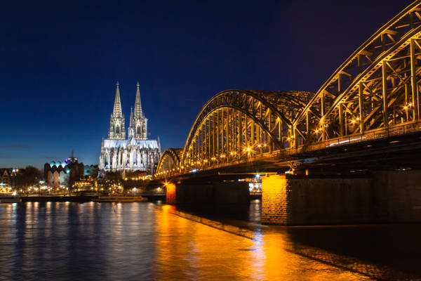 Aftenbillede af Hohenzollern-broen over Rhinen med Kölner Dom i baggrunden.