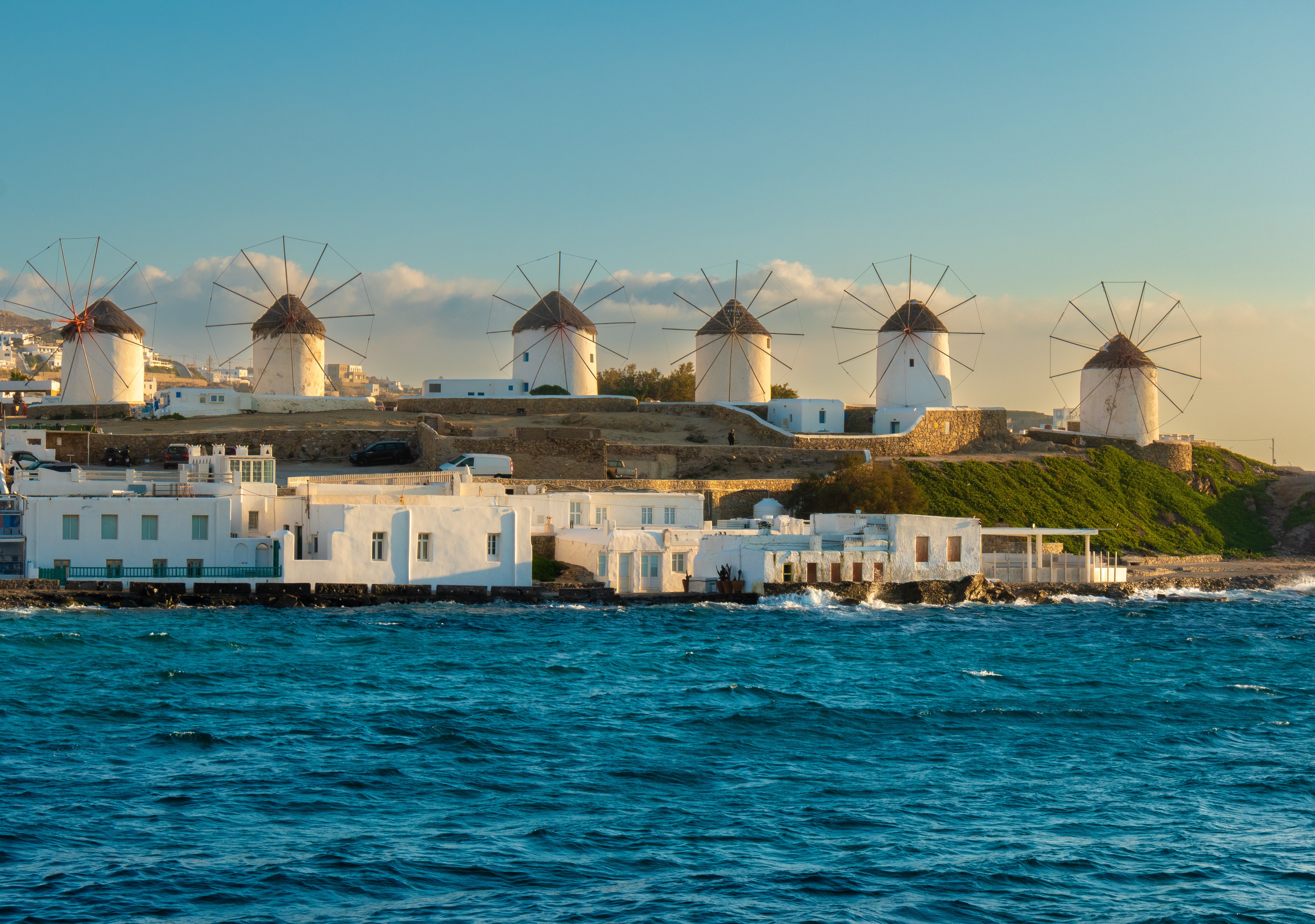 Kystlinjen ved Mykonos med hvide vindmøller på række.  