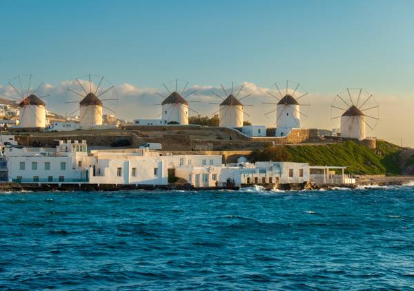Kystlinjen ved Mykonos med hvide vindmøller på række.