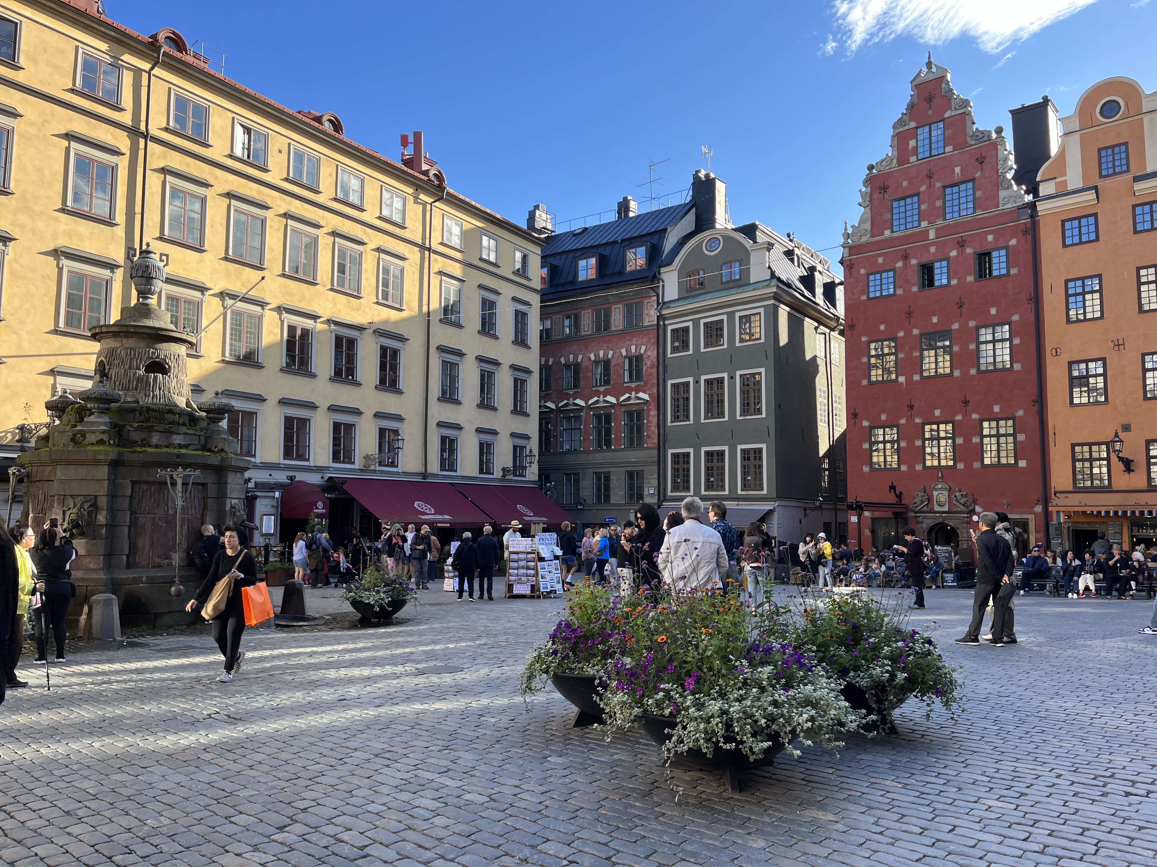 Sommerbillede af mennesker, der går på det brolagte Stortorget i Gamla Stan i Stockholm i Sverige.