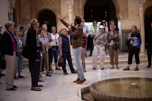 Guide fortæller en gruppe gæster om Alhambra-paladset i Granada i Spanien.