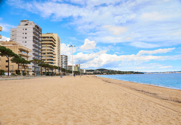 Den brede sandstrand ved feriebyen Platja d'Aro ved Costa Brava i Spanien.