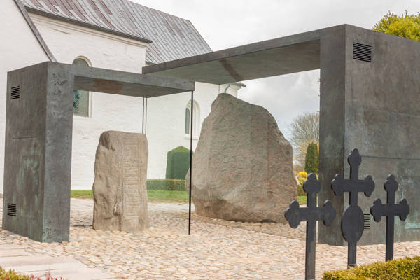 Jellingestenene i glasmontrer foran kirken i Jelling.