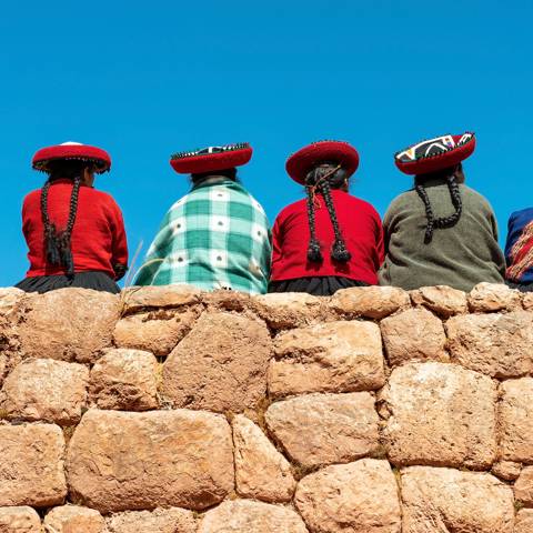 Fire kvinder i tradtionelt tøj i Ollantaytambo i Peru.