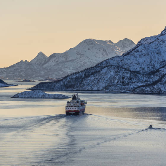 Hurtigrutens skib MS Richard With sejler i en vinterklædt fjord i Norge.