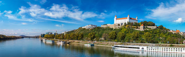 Flodkrydstogtskib ligger for kaj på Donau ved Bratislava slot i Slovakiet.
