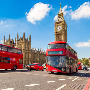 Røde dobbeltdækkerbusser på vejen foran parlamentet og Big Ben i London.