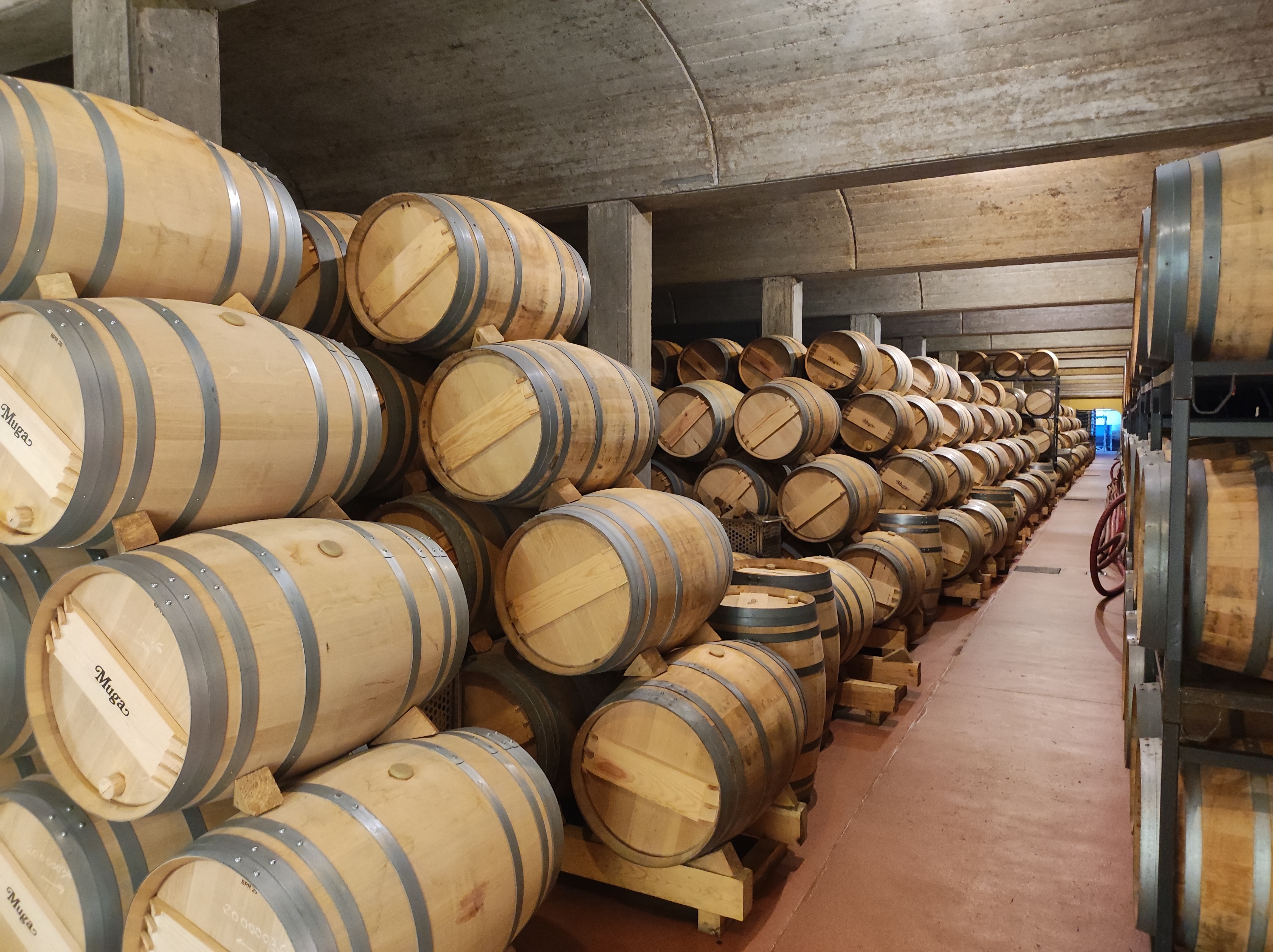 Egetræsfade på rad og række i en vinkælder i byen Haro i La Rioja-regionen i Spanien.