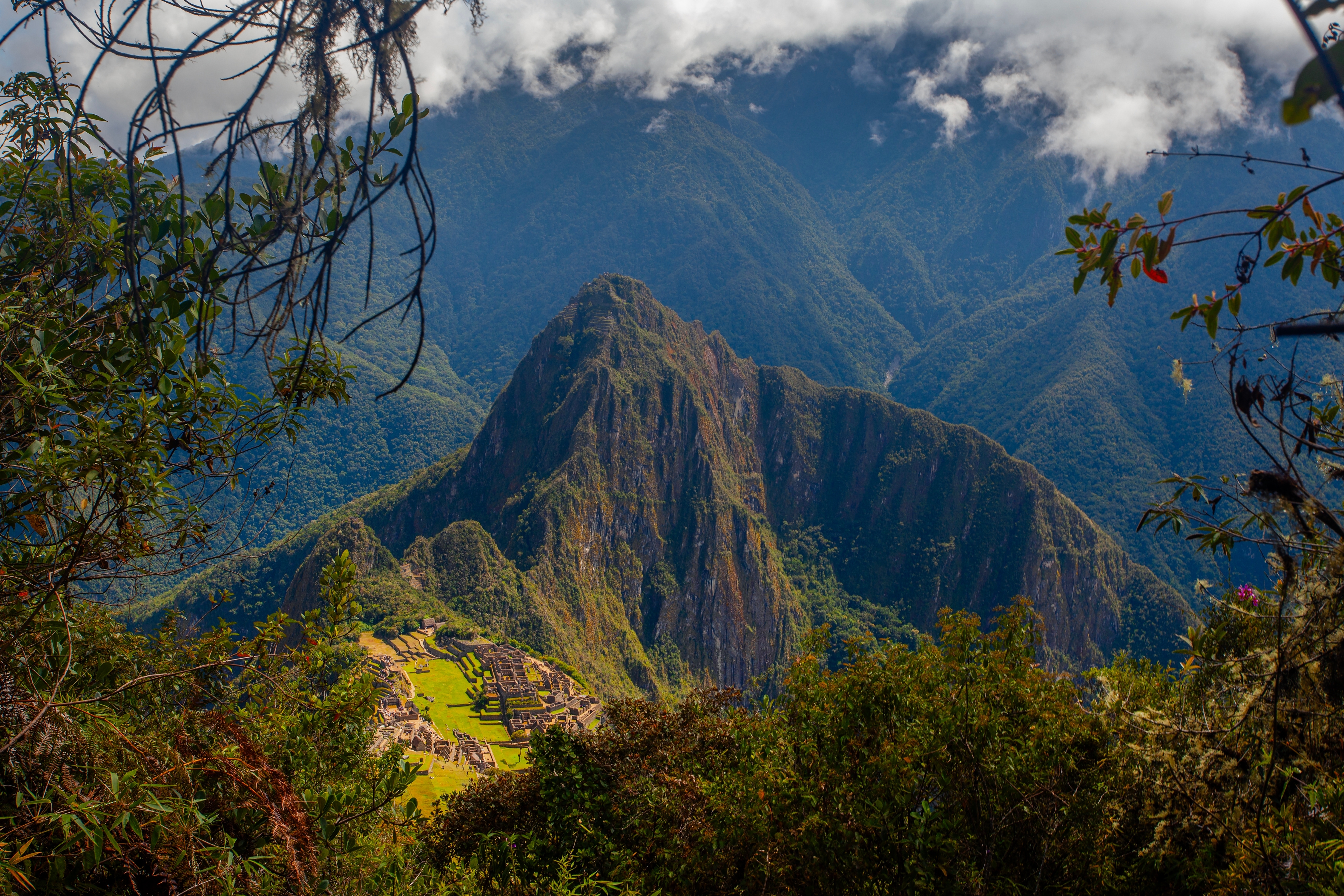 Panoramabillede af Macchu Picchu i Peru med Andesbjergene i baggrunden.