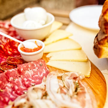 Anretning med charcuteri og ost på skærebræt.