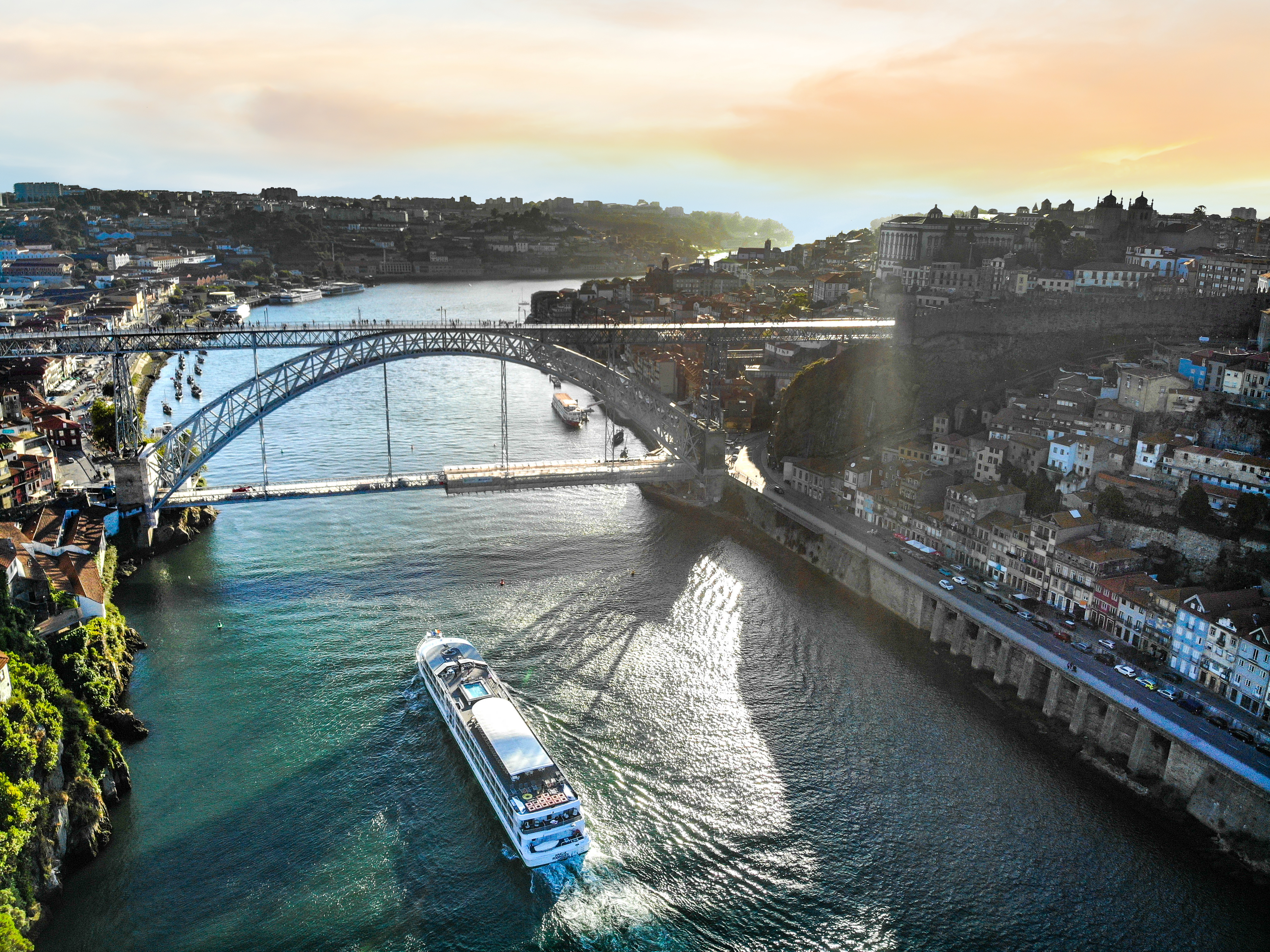 Luftfoto af flodkrydstogtskibet MS Amalia Rodrigues fra Croisi Europe der sejler under Dom Luis I-broen i Porto i Portugal.