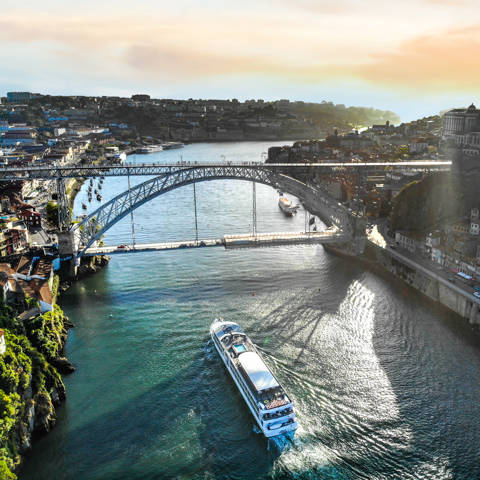 Luftfoto af flodkrydstogtskibet MS Amalia Rodrigues fra Croisi Europe der sejler under Dom Luis I-broen i Porto i Portugal.